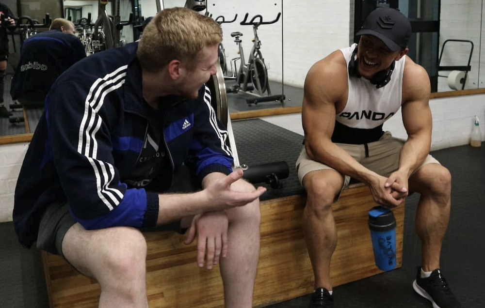 Stefan laughing with a client during a gym session