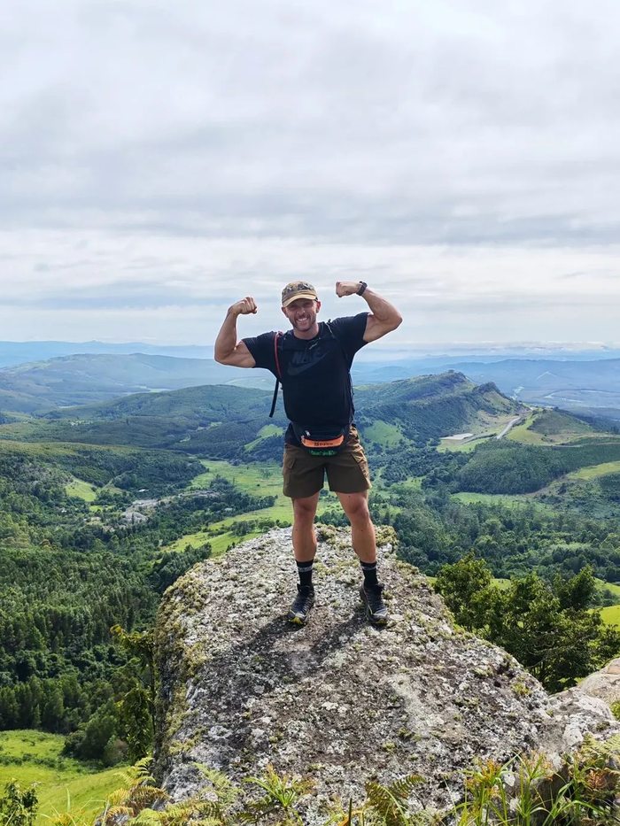 Stefan flexing on a mountain summit
