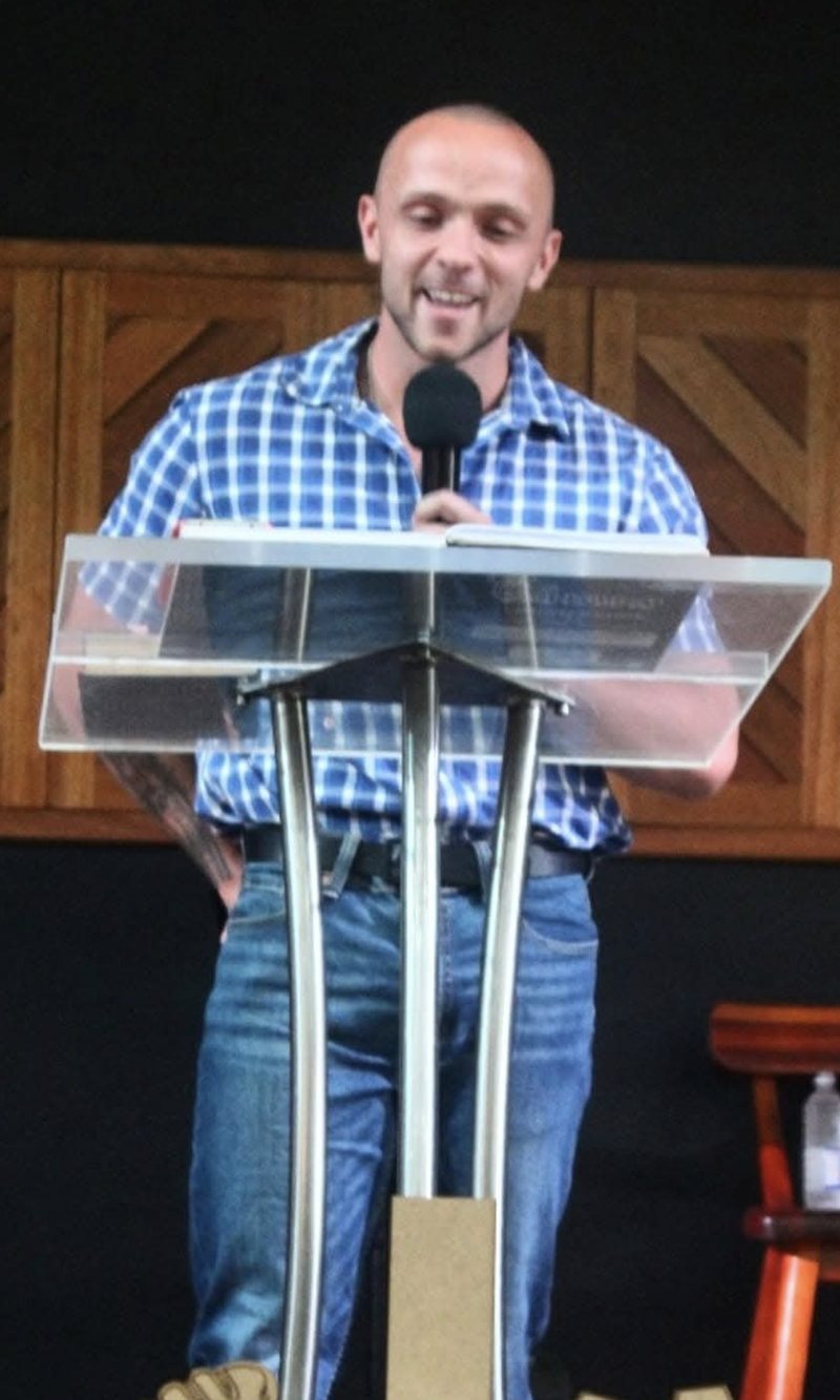 Stefan speaking with a microphone, blue shirt